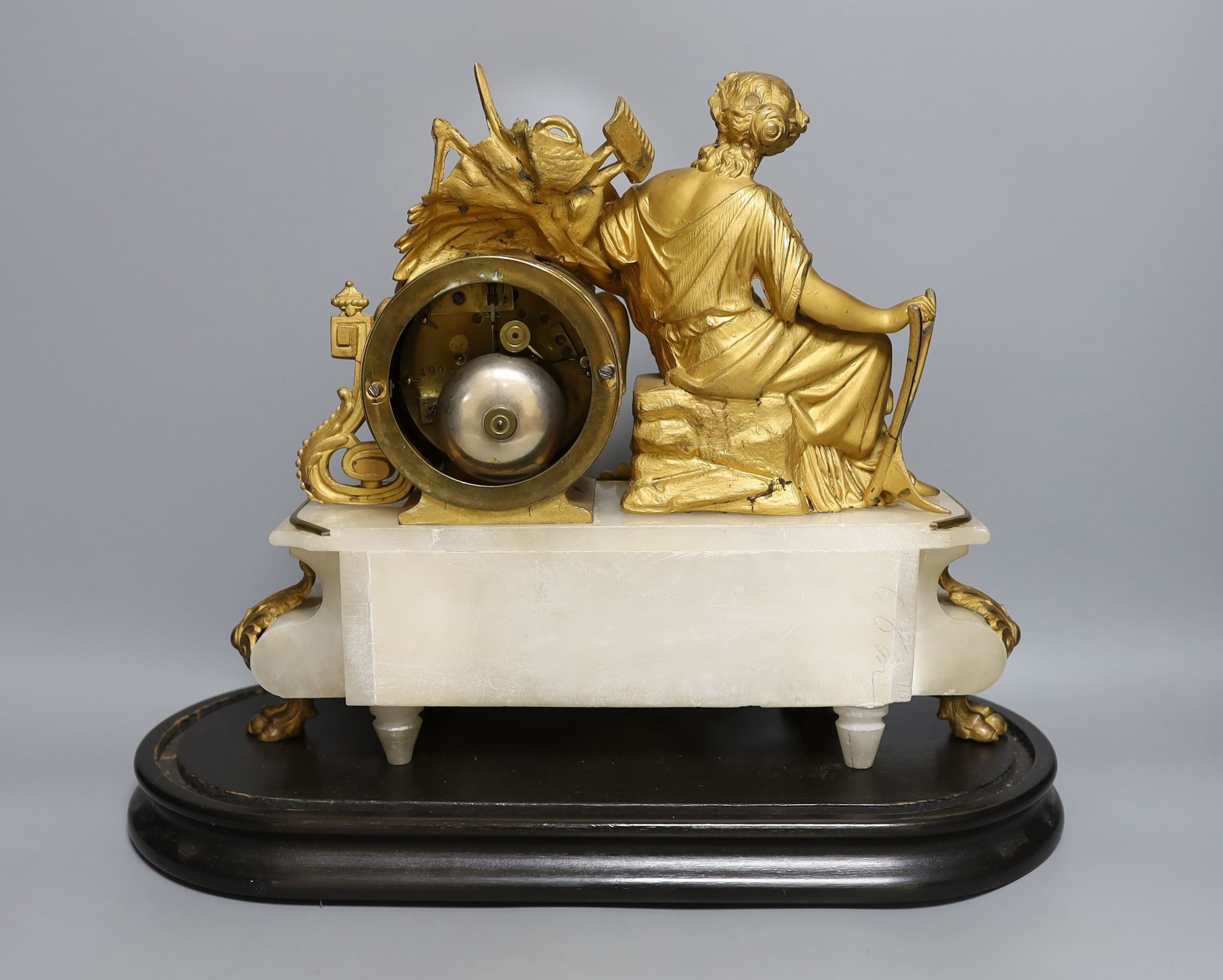 A 19th century French gilt metal and alabaster figural mantle clock with key and pendulum